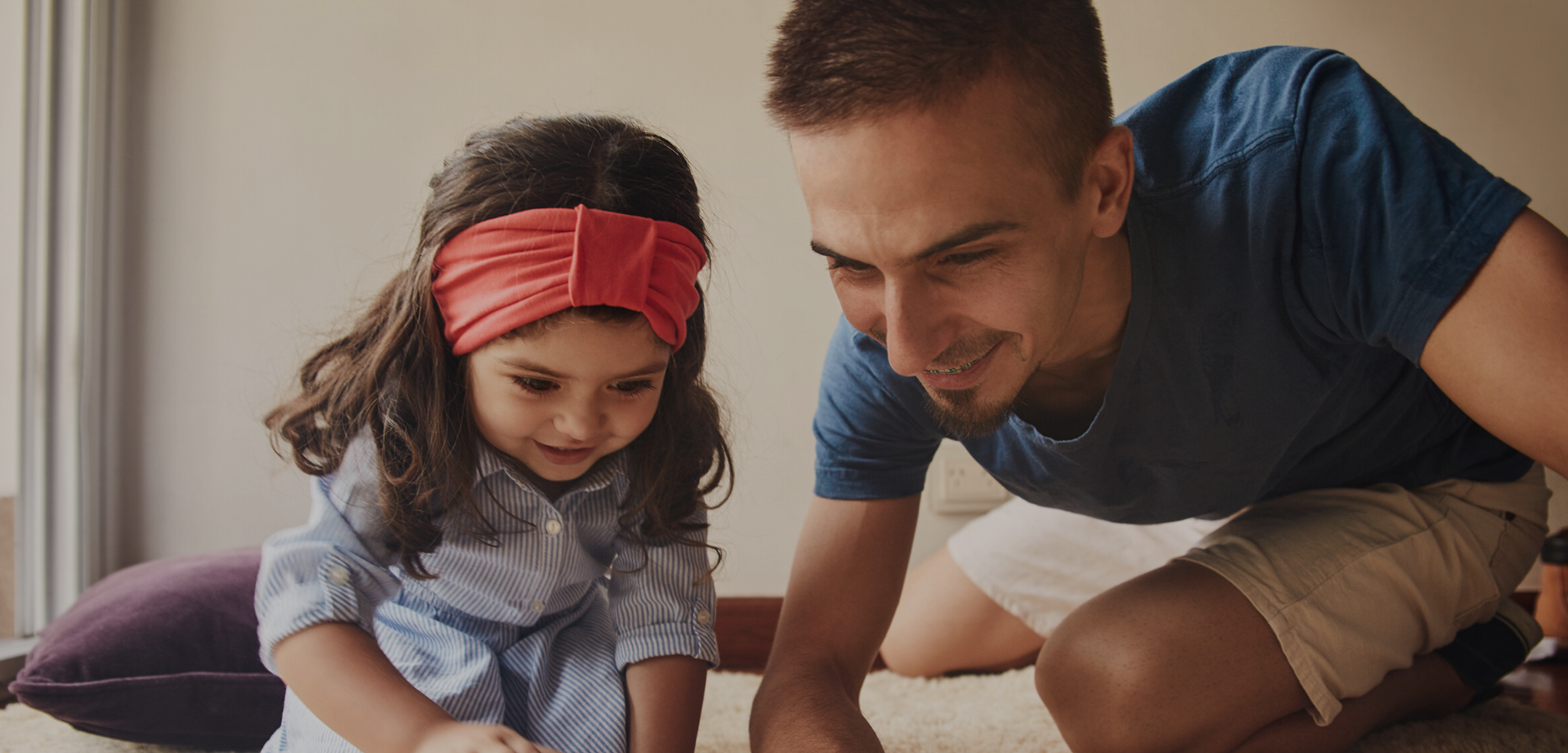 man with his little girl playing on the floor